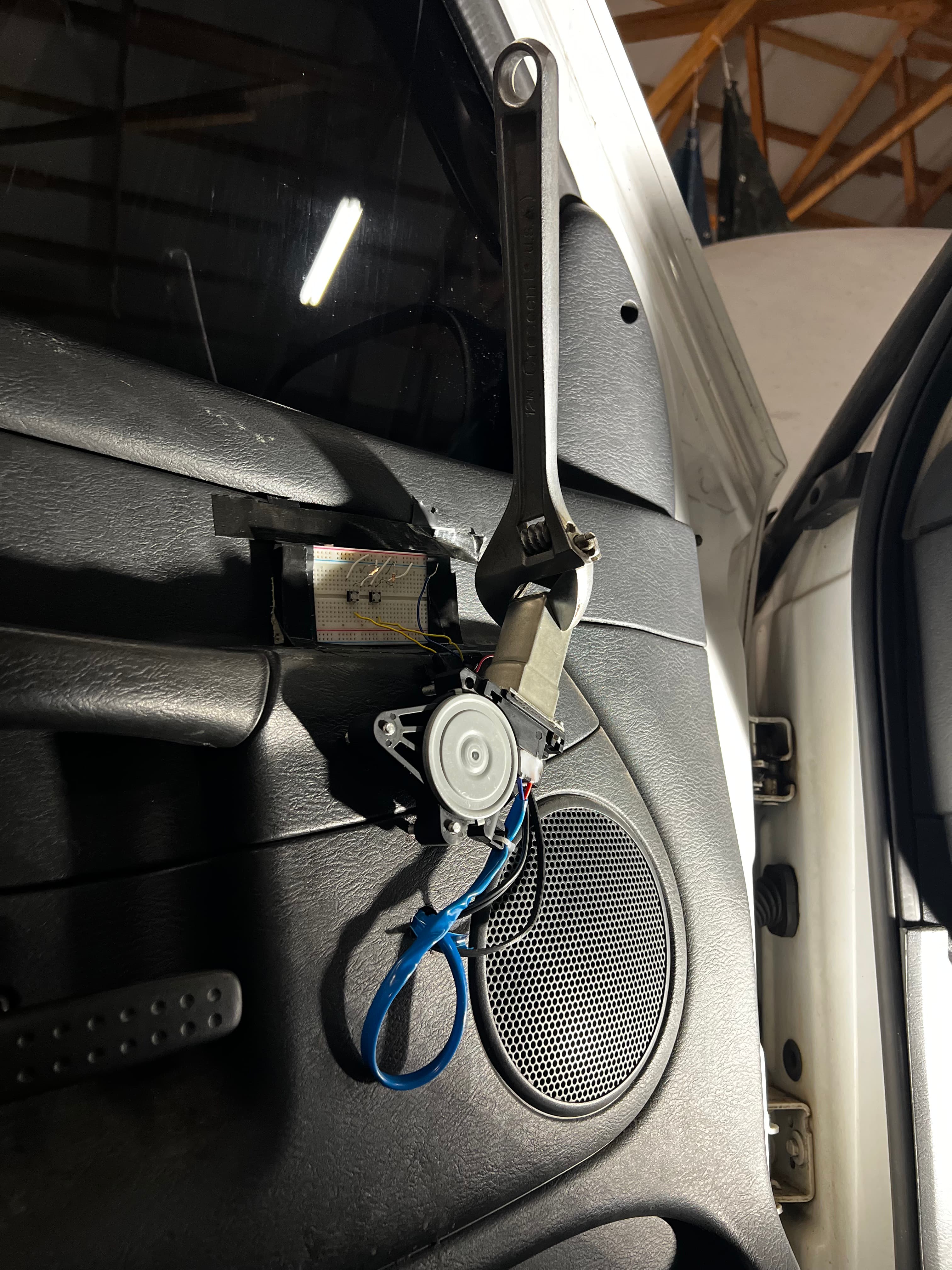 Truck door panel removed showing mounted motor, window arm, and breadboard